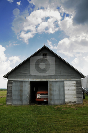 To use this stock image in your creative project, please select the size you need over to the right and click the "Add to Cart" button.
Your downloaded image will come with the Cutcaster watermark removed so don’t worry about the watermark you see on this page. Old truck in barn stock photo, An old truck in a barn under a cloudy blue sky. by W. Paul Thomas