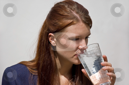 To use this stock image in your creative project, please select the size you need over to the right and click the "Add to Cart" button.
Your downloaded image will come with the Cutcaster watermark removed so don’t worry about the watermark you see on this page. Woman Drinking Ice Water stock photo, This pretty young Caucasian woman with red hair and wearing a navy colored blazer is drinking a glass of iced water on a light background. by Valerie Garner