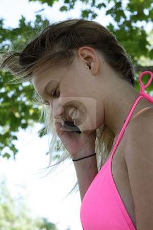 To use this stock image in your creative project, please select the size you need over to the right and click the "Add to Cart" button.
Your downloaded image will come with the Cutcaster watermark removed so don’t worry about the watermark you see on this page. A Young Woman on Her Cell Phone stock photo, A quiet scene in a park, by a lake, with a young woman talking on her cell phone. by Ray Carpenter