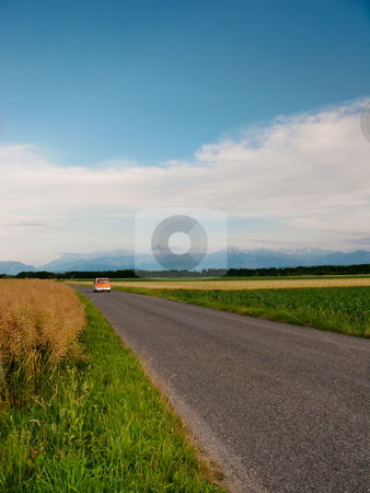 To use this stock image in your creative project, please select the size you need over to the right and click the "Add to Cart" button.
Your downloaded image will come with the Cutcaster watermark removed so don’t worry about the watermark you see on this page. Scenic countryside road stock photo, Small orange car driving on a French countryside road by Laurent Dambies