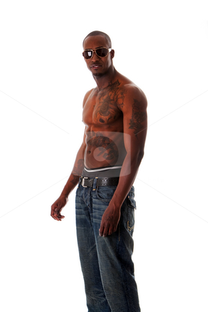 To use this stock image in your creative project, please select the size you need over to the right and click the "Add to Cart" button.
Your downloaded image will come with the Cutcaster watermark removed so don’t worry about the watermark you see on this page. Fit African man stock photo, Handsome fit African American male with tough attitude standing sideways, toned body and tattoos, wearing blue jeans and sunglasses, showing rim of underwear, isolated by Paul Hakimata