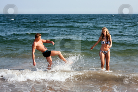 To use this stock image in your creative project, please select the size you need over to the right and click the "Add to Cart" button.
Your downloaded image will come with the Cutcaster watermark removed so don’t worry about the watermark you see on this page. Couple playing in ocean water stock photo, Beautiful young couple playing in the ocean splashing water, heaving fun on a summer day by Paul Hakimata