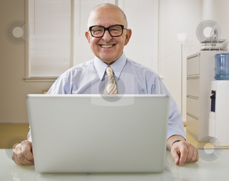 To use this stock image in your creative project, please select the size you need over to the right and click the "Add to Cart" button.
Your downloaded image will come with the Cutcaster watermark removed so don’t worry about the watermark you see on this page. Man on Laptop stock photo, An elderly man is on a laptop in an office. He is smiling at the camera. Horizontally framed shot. by Jonathan Ross