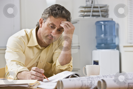 To use this stock image in your creative project, please select the size you need over to the right and click the "Add to Cart" button.
Your downloaded image will come with the Cutcaster watermark removed so don’t worry about the watermark you see on this page. Man Working on Blueprints stock photo, A businessman is working on blueprints in his office. He is looking away from the camera. Horizontally framed shot. by Jonathan Ross