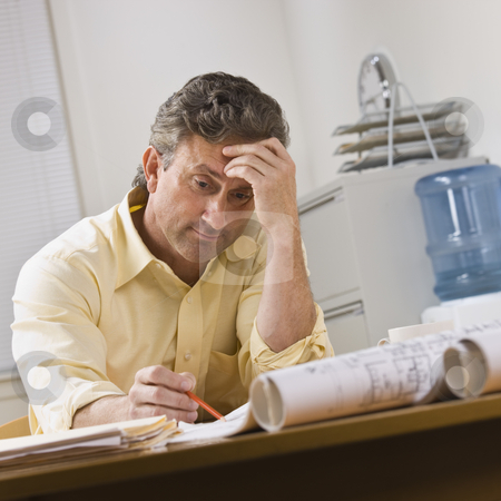 To use this stock image in your creative project, please select the size you need over to the right and click the "Add to Cart" button.
Your downloaded image will come with the Cutcaster watermark removed so don’t worry about the watermark you see on this page. Man Working on Blueprints stock photo, A businessman is working on blueprints in an office. He is looking away from the camera. Square framed shot. by Jonathan Ross