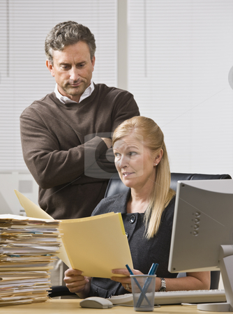 To use this stock image in your creative project, please select the size you need over to the right and click the "Add to Cart" button.
Your downloaded image will come with the Cutcaster watermark removed so don’t worry about the watermark you see on this page. Man Looking over Woman's Shoulder stock photo, A businessman is standing in an office behind the receptionist, and is looking over her shoulder to the file in her hands. She is looking away. Vertically framed shot. by Jonathan Ross