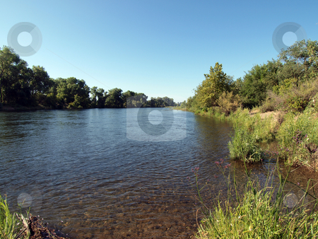 To use this stock image in your creative project, please select the size you need over to the right and click the "Add to Cart" button.
Your downloaded image will come with the Cutcaster watermark removed so don’t worry about the watermark you see on this page. View up river from banks blue sky summer day stock photo, View of river with green trees on banks and blue sky by Jeff Cleveland