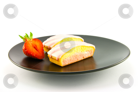 To use this stock image in your creative project, please select the size you need over to the right and click the "Add to Cart" button.
Your downloaded image will come with the Cutcaster watermark removed so don’t worry about the watermark you see on this page. Two Strawberry Slices stock photo, Two pink strawberry sliced cakes with icing on the top with a half strawberry on a black plate on a white background by Keith Wilson