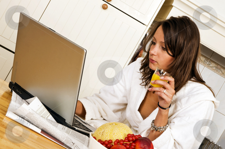 To use this stock image in your creative project, please select the size you need over to the right and click the "Add to Cart" button.
Your downloaded image will come with the Cutcaster watermark removed so don’t worry about the watermark you see on this page. Sunday brunch stock photo, Young woman, catching up with the day's events on her laptop whilst drinking a glass of orange jus, wearing a bathrobe by Corepics VOF