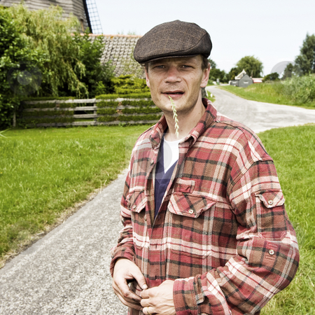 To use this stock image in your creative project, please select the size you need over to the right and click the "Add to Cart" button.
Your downloaded image will come with the Cutcaster watermark removed so don’t worry about the watermark you see on this page. Farmer stock photo, Portrait of a sturdy looking farmer, wearing a cap, chewing a grass halm by Corepics VOF