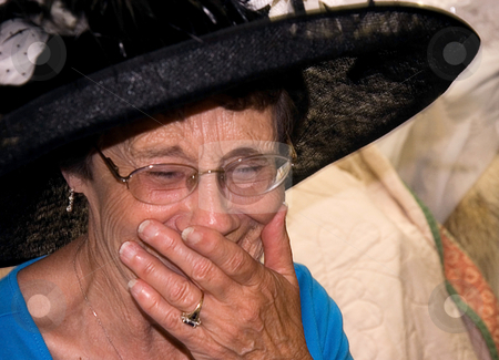To use this stock image in your creative project, please select the size you need over to the right and click the "Add to Cart" button.
Your downloaded image will come with the Cutcaster watermark removed so don’t worry about the watermark you see on this page. Elderly Woman Laughing stock photo, This elderly woman is laughing while wearing a black vintage hat and has her mouth covered with her hand. by Valerie Garner
