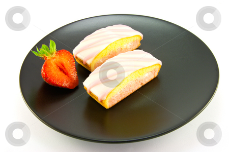 To use this stock image in your creative project, please select the size you need over to the right and click the "Add to Cart" button.
Your downloaded image will come with the Cutcaster watermark removed so don’t worry about the watermark you see on this page. Two Strawberry Slices stock photo, Two pink strawberry sliced cakes with icing on the top with a half strawberry on a black plate on a white background by Keith Wilson