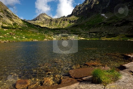 To use this stock image in your creative project, please select the size you need over to the right and click the "Add to Cart" button.
Your downloaded image will come with the Cutcaster watermark removed so don’t worry about the watermark you see on this page. Mountain lake with a peak stock photo, Mountain lake with a peak in the background by Juraj Kovacik