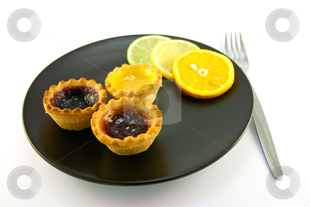 To use this stock image in your creative project, please select the size you need over to the right and click the "Add to Cart" button.
Your downloaded image will come with the Cutcaster watermark removed so don’t worry about the watermark you see on this page. Jam Tarts with Citrus Slices and Fork stock photo, Red and yellow small jam tarts with slices of lemon, lime, and orange on a black plate with a fork on a white background by Keith Wilson