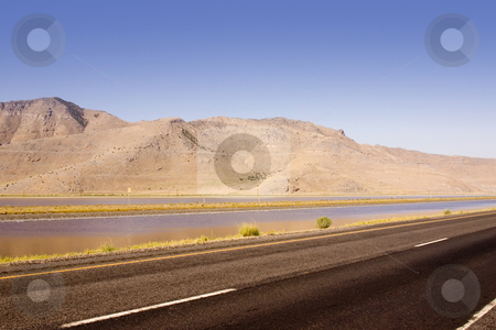 To use this stock image in your creative project, please select the size you need over to the right and click the "Add to Cart" button.
Your downloaded image will come with the Cutcaster watermark removed so don’t worry about the watermark you see on this page. Highway, Pond and the Mountain stock photo, Highway running by a Pond and the Mountain by Mehmet Dilsiz