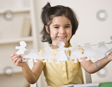 To use this stock image in your creative project, please select the size you need over to the right and click the "Add to Cart" button.
Your downloaded image will come with the Cutcaster watermark removed so don’t worry about the watermark you see on this page. Girl Making Paper Dolls stock photo, A young girl is seated at a desk and is holding up paper dolls. She is smiling at the camera. Horizontally framed shot. by Jonathan Ross
