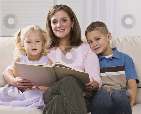 To use this stock image in your creative project, please select the size you need over to the right and click the "Add to Cart" button.
Your downloaded image will come with the Cutcaster watermark removed so don’t worry about the watermark you see on this page. Woman Reading to Children stock photo, A mother is reading to her two young children. They are all smiling at the camera. Square framed shot. by Jonathan Ross