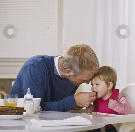 To use this stock image in your creative project, please select the size you need over to the right and click the "Add to Cart" button.
Your downloaded image will come with the Cutcaster watermark removed so don’t worry about the watermark you see on this page. Father Feeding Daughter Breakfast stock photo, A young father feeding his daughter cereal at a breakfast table. They are looking away from the camera. Square framed shot. by Jonathan Ross