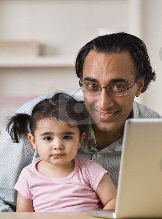 To use this stock image in your creative project, please select the size you need over to the right and click the "Add to Cart" button.
Your downloaded image will come with the Cutcaster watermark removed so don’t worry about the watermark you see on this page. Smiling Father With Daughter Sitting By Laptop stock photo, An Indian father holds his young daughter. He is smiling directly at the camera. There is a laptop on the table. Vertically framed shot. by Jonathan Ross