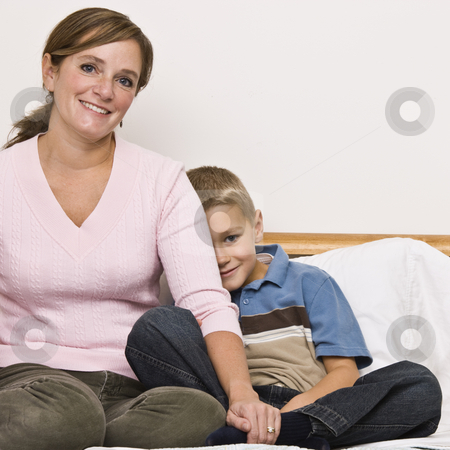 To use this stock image in your creative project, please select the size you need over to the right and click the "Add to Cart" button.
Your downloaded image will come with the Cutcaster watermark removed so don’t worry about the watermark you see on this page. Mother and Son Sitting on Bed stock photo, A mother and her young son are sitting on the bed together. They are both smiling at the camera. Square framed shot. by Jonathan Ross