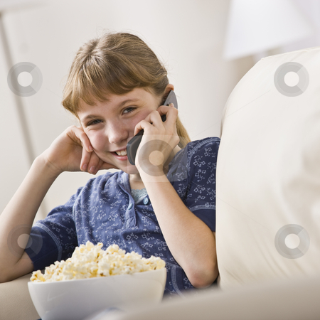 To use this stock image in your creative project, please select the size you need over to the right and click the "Add to Cart" button.
Your downloaded image will come with the Cutcaster watermark removed so don’t worry about the watermark you see on this page. Girl Talking on Cellphone stock photo, A young girl is seated on a living room sofa and is talking on a cellphone. She is smiling at the camera. Square framed shot. by Jonathan Ross