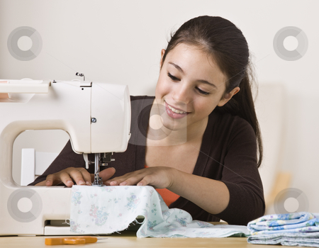 To use this stock image in your creative project, please select the size you need over to the right and click the "Add to Cart" button.
Your downloaded image will come with the Cutcaster watermark removed so don’t worry about the watermark you see on this page. Beautiful Girl Sewing stock photo, A beautiful, smiling young girl sewing on a sewing machine. Horizontally framed shot. by Jonathan Ross