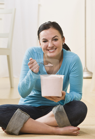 To use this stock image in your creative project, please select the size you need over to the right and click the "Add to Cart" button.
Your downloaded image will come with the Cutcaster watermark removed so don’t worry about the watermark you see on this page. Woman Eating Ice Cream stock photo, A young woman is sitting on the floor and eating ice cream out of a tub. She is smiling at the camera. Vertically framed shot. by Jonathan Ross
