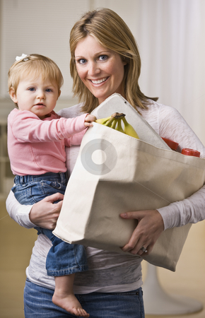 To use this stock image in your creative project, please select the size you need over to the right and click the "Add to Cart" button.
Your downloaded image will come with the Cutcaster watermark removed so don’t worry about the watermark you see on this page. Mother Holding Daughter and Groceries stock photo, A young mother is holding her daughter in one arm and a bag of groceries in the other. She is smiling at the camera. Vertically framed shot. by Jonathan Ross