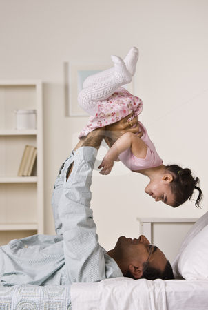 To use this stock image in your creative project, please select the size you need over to the right and click the "Add to Cart" button.
Your downloaded image will come with the Cutcaster watermark removed so don’t worry about the watermark you see on this page. Father Playing with Daughter stock photo, A man is laying on a bed and holding up his baby daughter. They are smiling at each other. Vertically framed shot. by Jonathan Ross