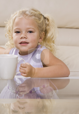 To use this stock image in your creative project, please select the size you need over to the right and click the "Add to Cart" button.
Your downloaded image will come with the Cutcaster watermark removed so don’t worry about the watermark you see on this page. Girl Drinking out of Mug stock photo, A young girl is sitting at the coffee table and drinking out of a mug. She is looking at the camera. Vertically framed shot. by Jonathan Ross