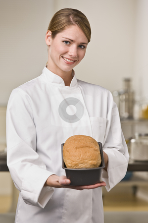 To use this stock image in your creative project, please select the size you need over to the right and click the "Add to Cart" button.
Your downloaded image will come with the Cutcaster watermark removed so don’t worry about the watermark you see on this page. Baker with Loaf of Bread stock photo, A young woman is standing in a kitchen and holding out a loaf of bread. She is smiling at the camera. Vertically framed shot. by Jonathan Ross