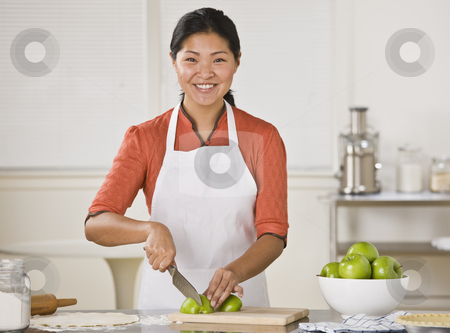 To use this stock image in your creative project, please select the size you need over to the right and click the "Add to Cart" button.
Your downloaded image will come with the Cutcaster watermark removed so don’t worry about the watermark you see on this page. Asian woman slicing apples. stock photo, Smiling Asian woman standing at counter and slicing apples.Horizontal by Jonathan Ross