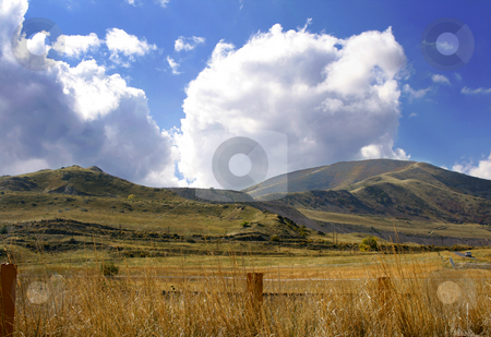To use this stock image in your creative project, please select the size you need over to the right and click the "Add to Cart" button.
Your downloaded image will come with the Cutcaster watermark removed so don’t worry about the watermark you see on this page. Country with Mountains stock photo, Country with Mountains and Cloudy Skies by Mehmet Dilsiz