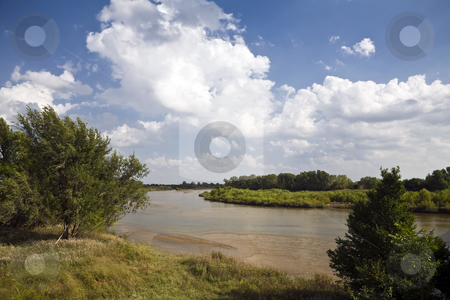 To use this stock image in your creative project, please select the size you need over to the right and click the "Add to Cart" button.
Your downloaded image will come with the Cutcaster watermark removed so don’t worry about the watermark you see on this page. Arkansas River stock photo, The Arkansas River meanders over the plains north of Wichita, Kansas under a partly cloudy sky by Bart Everett