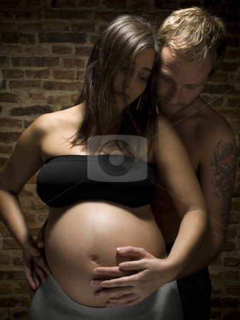 To use this stock image in your creative project, please select the size you need over to the right and click the "Add to Cart" button.
Your downloaded image will come with the Cutcaster watermark removed so don’t worry about the watermark you see on this page. Young new family stock photo, A man holding his pregnant wife's belly. by Ignacio Gonzalez Prado