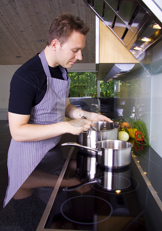 To use this stock image in your creative project, please select the size you need over to the right and click the "Add to Cart" button.
Your downloaded image will come with the Cutcaster watermark removed so don’t worry about the watermark you see on this page. Man cooking stock photo, Man cooking and stirring in the casserole by Daniel Kafer