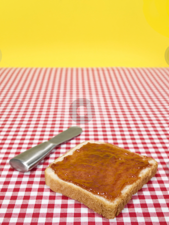 To use this stock image in your creative project, please select the size you need over to the right and click the "Add to Cart" button.
Your downloaded image will come with the Cutcaster watermark removed so don’t worry about the watermark you see on this page. One toast stock photo, A slice of bread spread with jam and a knife over the table. by Ignacio Gonzalez Prado