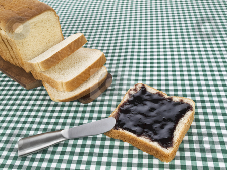 To use this stock image in your creative project, please select the size you need over to the right and click the "Add to Cart" button.
Your downloaded image will come with the Cutcaster watermark removed so don’t worry about the watermark you see on this page. Spread the jam stock photo, A slice of bread spread with jam beside the loaf of bread. by Ignacio Gonzalez Prado