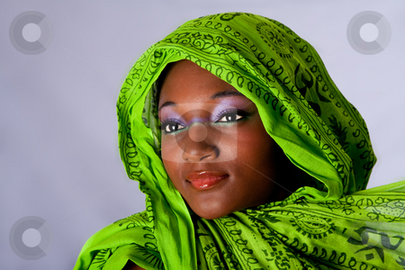 To use this stock image in your creative project, please select the size you need over to the right and click the "Add to Cart" button.
Your downloaded image will come with the Cutcaster watermark removed so don’t worry about the watermark you see on this page. African woman with headwrap stock photo, The face of an innocent beautiful young African-American woman with green headwrap and purple-green makeup, isolated by Paul Hakimata