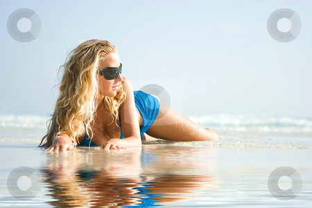 To use this stock image in your creative project, please select the size you need over to the right and click the "Add to Cart" button.
Your downloaded image will come with the Cutcaster watermark removed so don’t worry about the watermark you see on this page. Girl on beach with reflection in water stock photo, Blond girl in sunglasses lying on the beach with reflection in water by Dmitry Rostovtsev