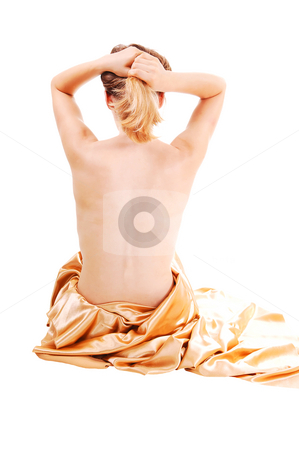 To use this stock image in your creative project, please select the size you need over to the right and click the "Add to Cart" button.
Your downloaded image will come with the Cutcaster watermark removed so don’t worry about the watermark you see on this page. Young topless woman. stock photo, A young girl, topless and holding her hair up, sitting on the floor wrapped
in an gold silk cloth, shooing her flawless back, on white background. by Horst Petzold