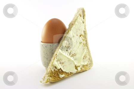 To use this stock image in your creative project, please select the size you need over to the right and click the "Add to Cart" button.
Your downloaded image will come with the Cutcaster watermark removed so don’t worry about the watermark you see on this page. Lightly Boiled Egg and Toast stock photo, Lightly boiled egg in an egg cup with a slice of buttered toast on a white background by Keith Wilson
