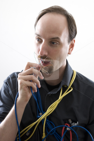 To use this stock image in your creative project, please select the size you need over to the right and click the "Add to Cart" button.
Your downloaded image will come with the Cutcaster watermark removed so don’t worry about the watermark you see on this page. Eating wires stock photo, Computer technician cluess trying to eat network wire by Yann Poirier