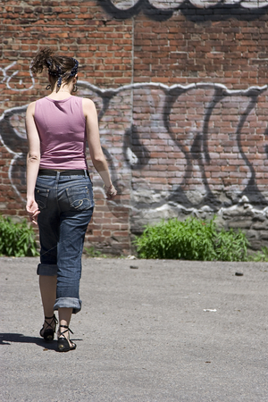 To use this stock image in your creative project, please select the size you need over to the right and click the "Add to Cart" button.
Your downloaded image will come with the Cutcaster watermark removed so don’t worry about the watermark you see on this page. Walking away stock photo, Teenage girl walking away in a parking lot, heading towards a brick wall with graffiti by Yann Poirier