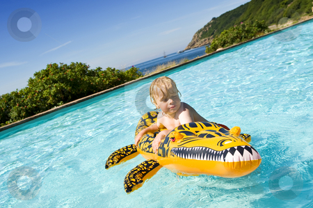 To use this stock image in your creative project, please select the size you need over to the right and click the "Add to Cart" button.
Your downloaded image will come with the Cutcaster watermark removed so don’t worry about the watermark you see on this page. Boy in pool stock photo, Young boy playing with an inflatable crocodile in an outdoor pool near the sea by Corepics VOF