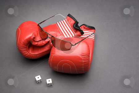 To use this stock image in your creative project, please select the size you need over to the right and click the "Add to Cart" button.
Your downloaded image will come with the Cutcaster watermark removed so don’t worry about the watermark you see on this page. Fight and gambling stock photo, Men's sunglasses place on top of boxing gloves with a pair of dice rolled on snake eyes by Yann Poirier