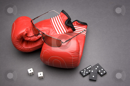 To use this stock image in your creative project, please select the size you need over to the right and click the "Add to Cart" button.
Your downloaded image will come with the Cutcaster watermark removed so don’t worry about the watermark you see on this page. Game of chance and skill stock photo, Men's sunglasses place on top of boxing gloves with a pair of dice rolled on snake eyes and three dominos by Yann Poirier