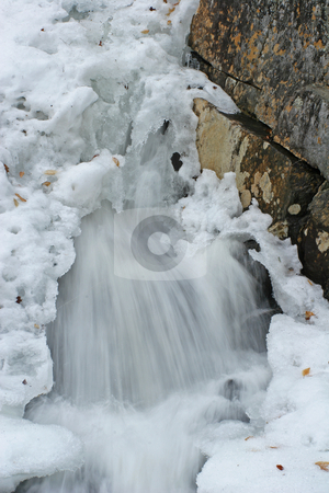 To use this stock image in your creative project, please select the size you need over to the right and click the "Add to Cart" button.
Your downloaded image will come with the Cutcaster watermark removed so don’t worry about the watermark you see on this page. Snow covered stream stock photo, Water falls moving out from under snow pack with rock on side by Marianne Dent