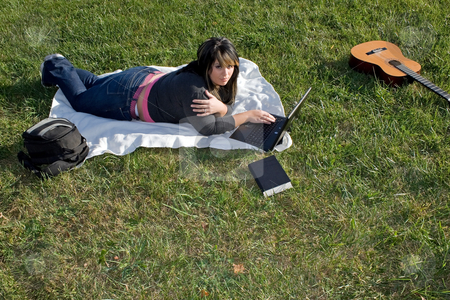 To use this stock image in your creative project, please select the size you need over to the right and click the "Add to Cart" button.
Your downloaded image will come with the Cutcaster watermark removed so don’t worry about the watermark you see on this page. Woman Using a Laptop stock photo, A young woman laying in the grass and using her laptop computer. She could be a college student or even a musician. by Todd Arena