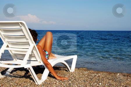 To use this stock image in your creative project, please select the size you need over to the right and click the "Add to Cart" button.
Your downloaded image will come with the Cutcaster watermark removed so don’t worry about the watermark you see on this page. Girl on beach stock photo, Young girl lying in chair on beach looking at sea view by Julija Sapic